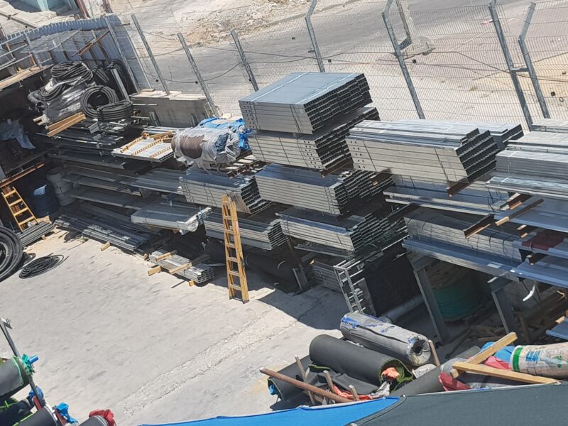 מבט מלמעלה על פרופילי מתכת וצינורות בחצר האחסון