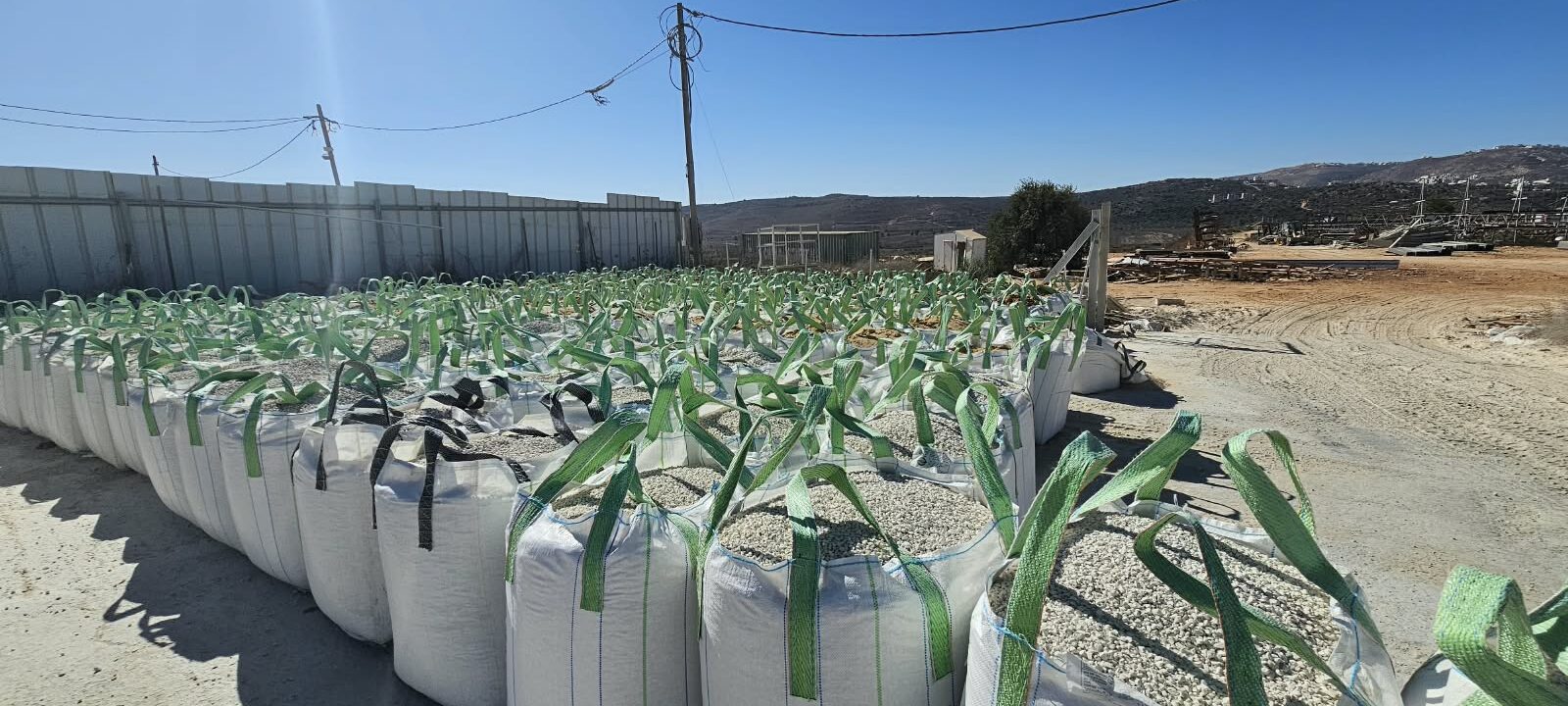 שקי ענק של אגרגטים מסודרים בשורות בחצר