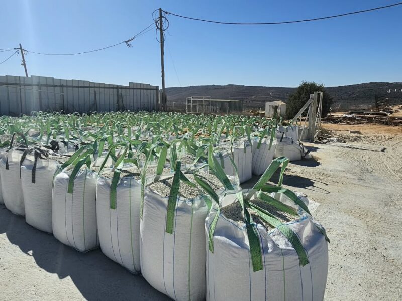 שקי ענק של חצץ בחצר האחסון על רקע ההרים